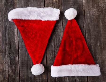Two Santa Claus helper hats on rustic wooden background. Christmas and New Year celebrationの写真素材