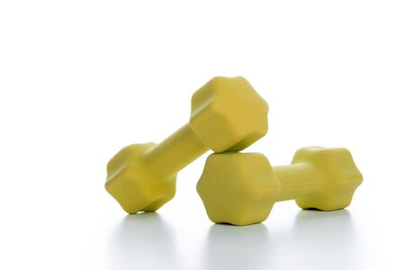 Fitness concept with two yellow dumbbells on white background, closeupの写真素材