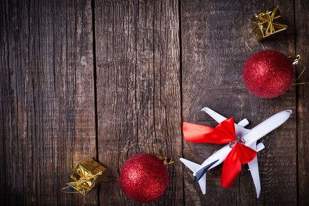 White blank model of passenger plane and christmas decoration toys on rustic wooden background. New Year celebrationの写真素材