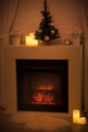 Burning fireplace in cozy living room decorated for Christmas, blurred image for backgroundの写真素材