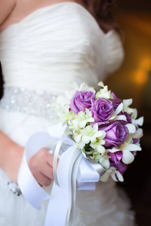 Wedding rose bouquet in bride's hand, shallow depthの写真素材