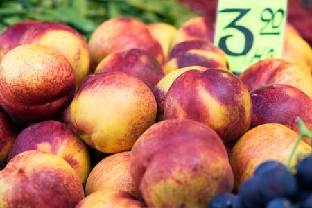 Pile of delicious ripe nectarines closeup on sale at street market counter, nobodyの写真素材