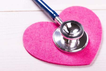 Stethoscope on heart shape over white wooden background, closeupの写真素材