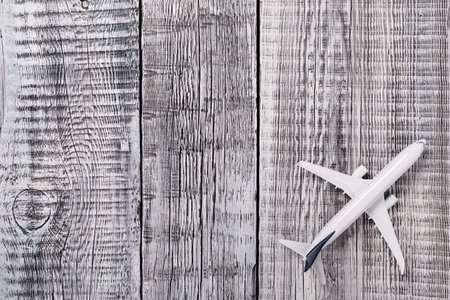 White blank model of passenger plane on rustic wooden background