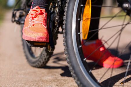 Woman riding a mountain bicycle along path at the forest. Closeup on pedal and foot. Healthy lifestyle and sport conceptの写真素材
