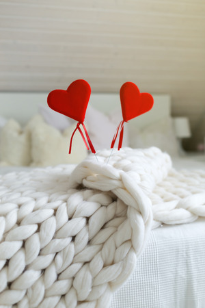 St. Valentine concept decoration card. Red heart shape on soft woolie knitted backgroundの写真素材