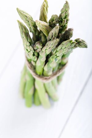 Fresh green asparagus on white wooden board, macro and shallow depthの写真素材