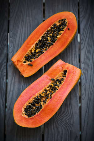 Slices of fresh cutted papaya on dark board, healthy detox concept, top viewの写真素材