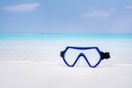 Swimming mask on white sandy seashore. Tropical vacation on beachの写真素材