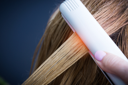 Keratin recovery and protein treatment with professional infrared iron tool. Concept of trendy laminating and strengthening care for damaged splitting hairs ends.の写真素材