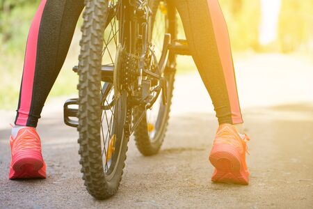 Woman riding a mountain bicycle along path at the forest. Closeup on pedal and foot. Healthy lifestyle and sport concept の写真素材