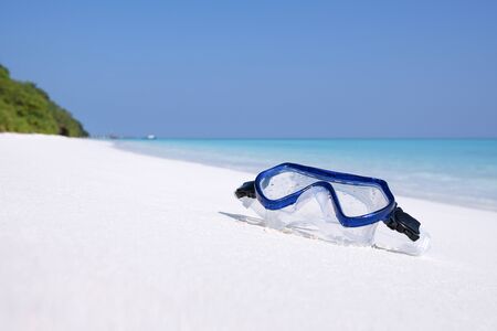 Swimming mask on white sandy seashore. Tropical vacation on beachの写真素材