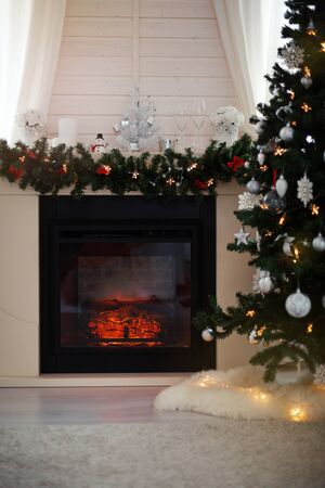 Scandinavian interior of rustic living room with fireplace decorated for Christmas holidays, greeting card, nobodyの写真素材