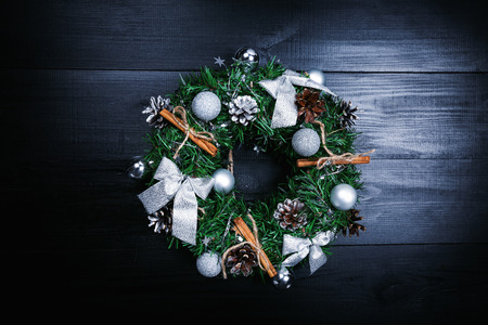 Traditional Christmas wreath with silver colours for winter holidays, handmade decoration on dark wooden table, top view with copy spaceの写真素材