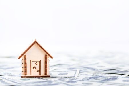 Mortgage concept. Wooden model of house on dollar banknotes backgroundの写真素材