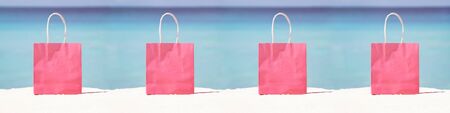 Shopping bags on sand against turquoise caribbean sea water. Tropical celebration on beach
の写真素材