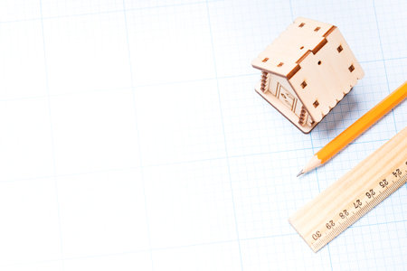 Planning design of new project. Wooden model of house, pencil and ruler on plotting paper