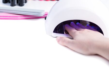  Gel nail procedure - Woman put hand in led lamp dryer on white table
の写真素材