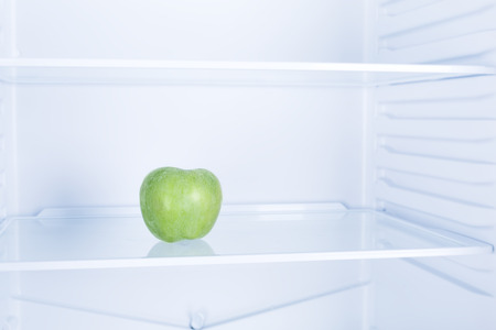 Green apple fruit inside in empty clean refrigerator with opened door, nobodyの写真素材