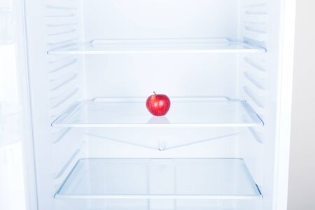 Red apple fruit inside in empty clean refrigerator with opened door, nobodyの写真素材