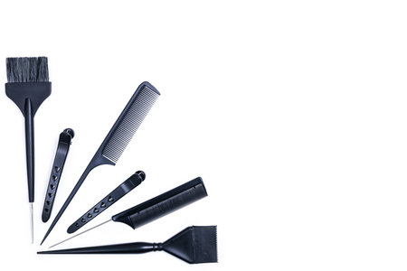 Hairdressing tools with copy space, combs and bleach brushes on white background, top view and flat...