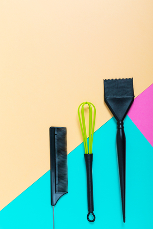 Hairdressing tools with copy space, combs and bleach brushes on pastel colored paper background, top view and flat layの写真素材