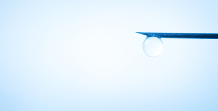 Drop on syringe needle. Medicine concept. Blue toneの写真素材