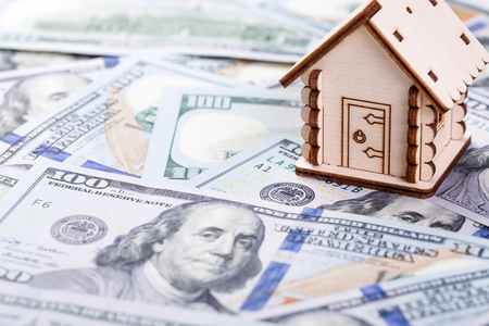 Mortgage concept. Wooden model of house on dollar banknotes backgroundの写真素材