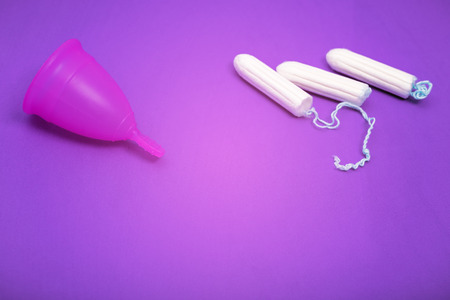 Pink menstrual cup on color background, female intimate hygiene period products, top viewの写真素材