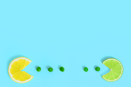 Lemon and lime fruits eating green peas on creative color paper background. Trendy minimal pop art...