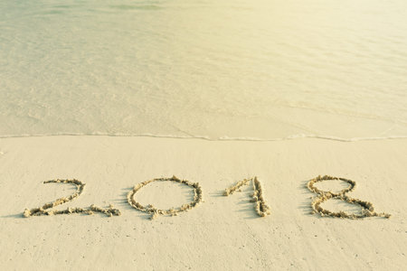 Handwritting inscription numbers 2018 on perfect tropical sandy beach, travel vacation concept card...