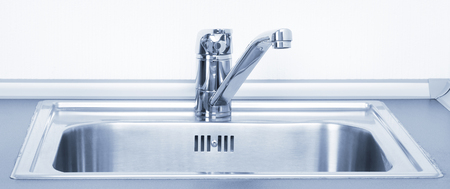 Faucet and metal sink, closeup on the kitchen. Blue toneの写真素材