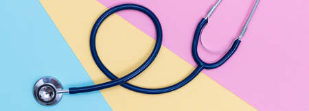 Stethoscope on pastel colored paper texture, flat layの写真素材