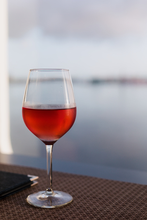 Glass of rose wine closeup on table close to menu, copy spaceの写真素材