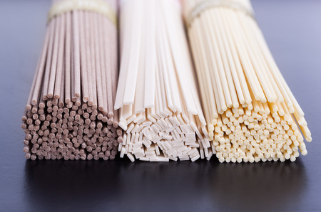 Different uncooked asian noodles closeup on black backgroundの写真素材