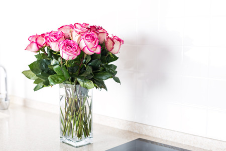 Modern design kitchen interior in minimal style decorated pink roses flowers in vaseの写真素材