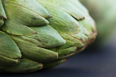 Artichokes on dark background, fresh textured green artichoke flowerの写真素材