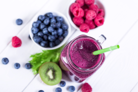 Mason jars with blueberry and raspberry fresh smoothie, top view on white wooden background, no peopleの写真素材