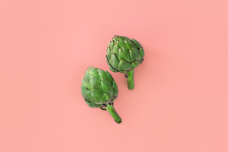 Colorful artichokes on color paper background, food creative colour conceptの写真素材