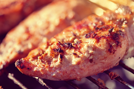 Grilled chicken breast on barbeque, macro cooking processの写真素材