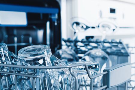 Empty dishwasher with opened door, home appliance dishwashing machine in kitchen interior, no peopleの写真素材