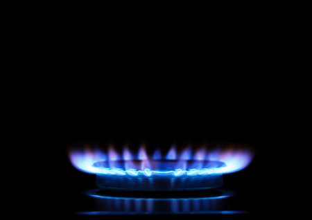 Kitchen burner flaming in the dark, closeup