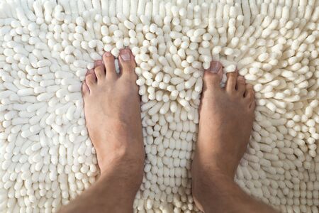 Male legs on fluffy carpet at bathroom. Top viewの写真素材
