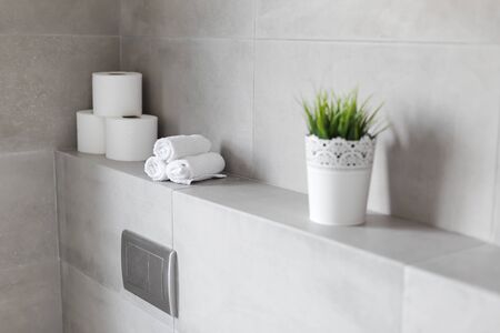 Rolled white towels and toilet paper rolls at restroom, nobodyの写真素材