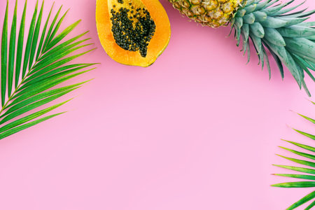Tropical fruits on pink color background. Pineapple, papaya, and mango flat lay. Summer food concept