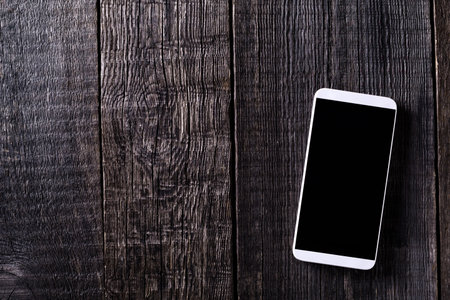 Smartphone on wooden rustic background. Top view. Nobody