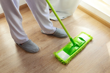 Home, housekeeping concept. Household equipment - cleaning wooden floor with mop, closeup,  indoors