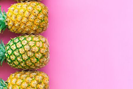 Pineapple tropical fruit on pink pastel background, frame with copy space, summer menu concept, flat layの写真素材