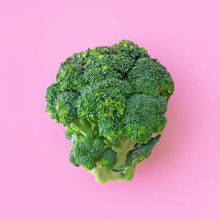 Fresh green broccoli on paper pink background. Organic summer vegetables for diet food concept, flat layの写真素材