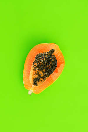 Top view of ripe half cut papaya on color background. Healthy summer food concept with tropical fruits, flat layの写真素材